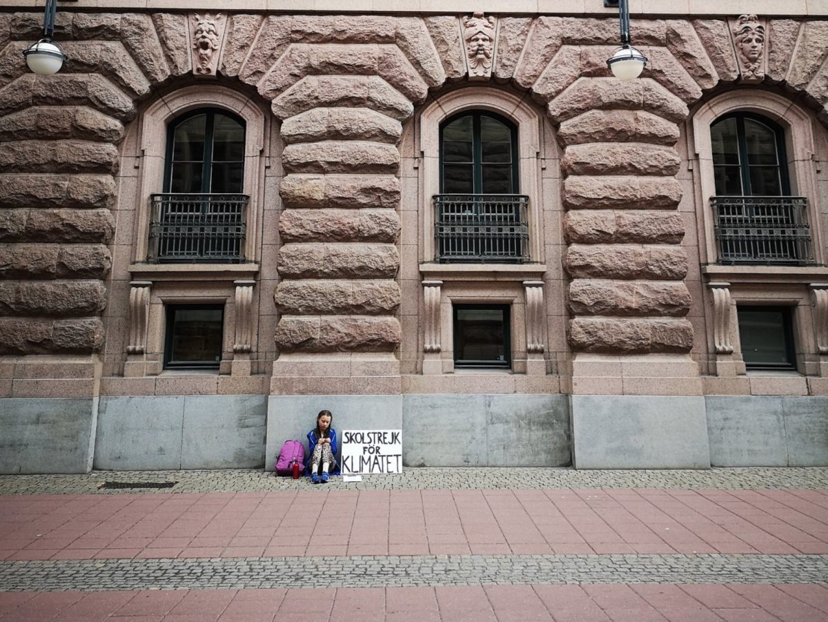 (Greta Thunberg sits by her Skolstrejk För Klimatet sign, August 2018. (Sveriges Riksdag)