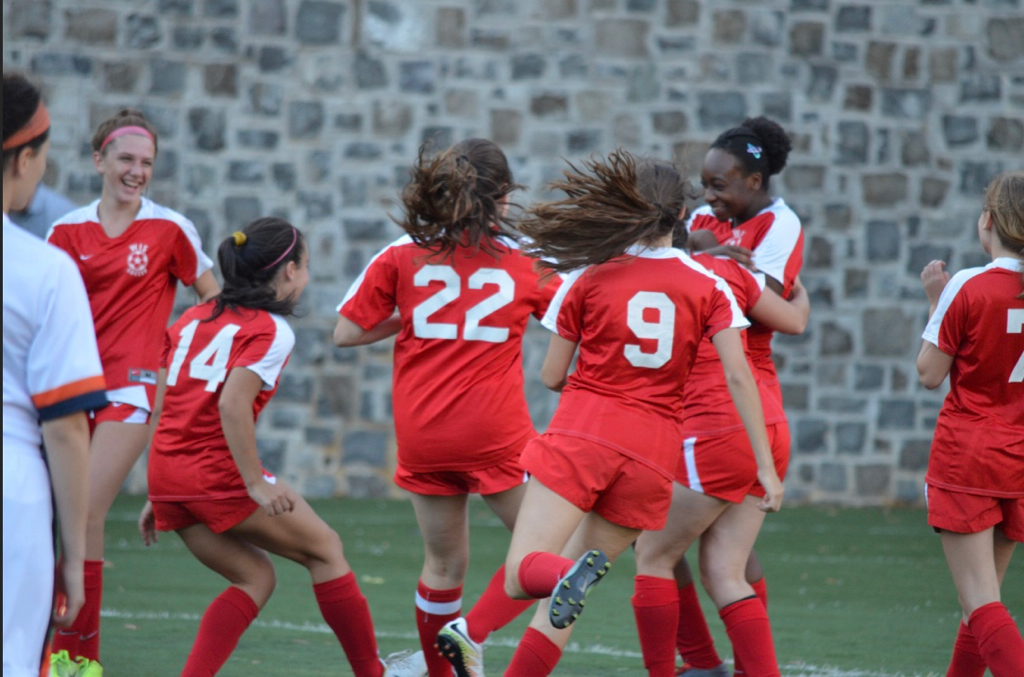 WIS girls varsity soccer celebrate a goal. Defender Riley Contee scores for the first time in high school. (Nico Vallada/International Dateline)