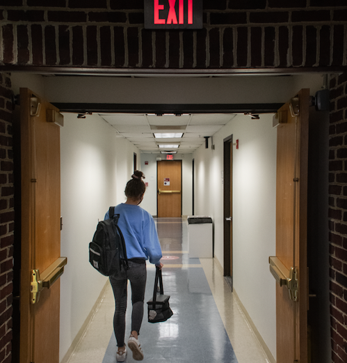 Student walking through empty hallways at the beginning of hybrid (Zach Roberts/International Dateline). 