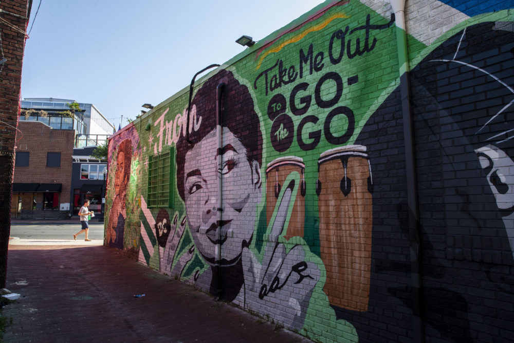 A mural decorates a building behind a Metro PCS store, Saturday, May 25, 2019 in the Shaw neighborhood of Washington. (AP Photo/Alex Brandon)