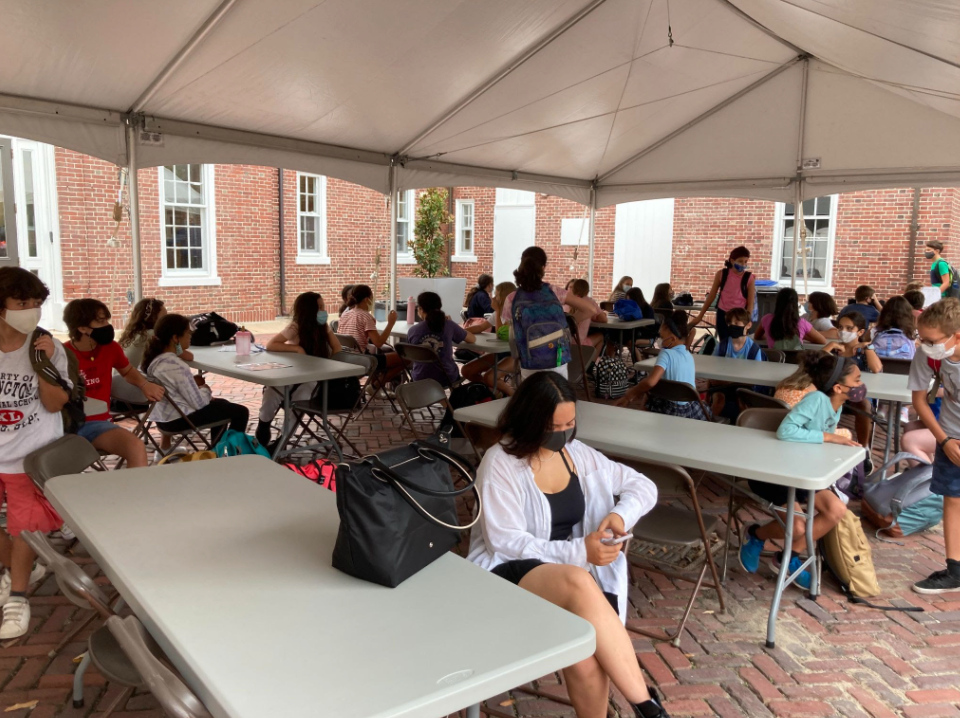 Middle School students socializing under the Carriage House tent before school. Now that all students are back on campus, they get to socialize with their friends more often (Martina Tognato Guaqueta/International Dateline).