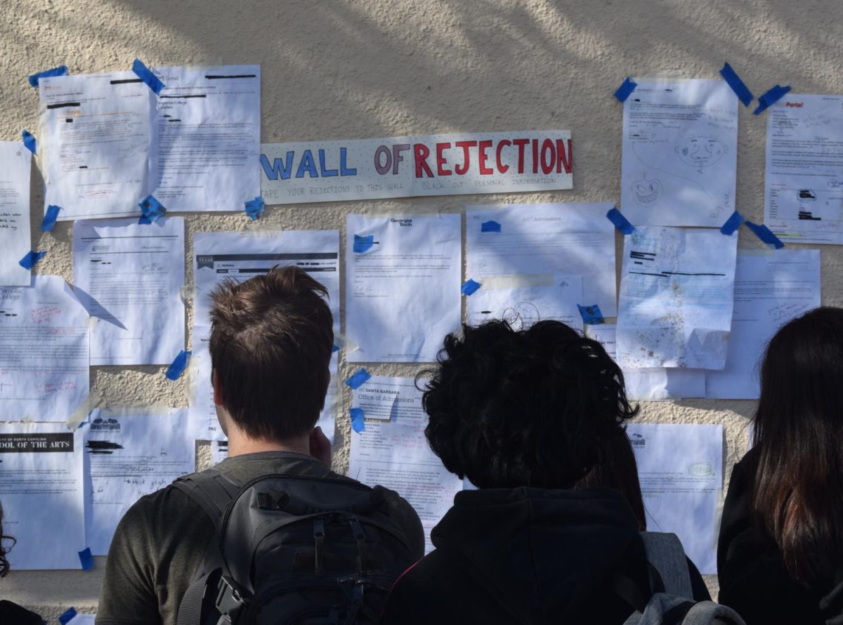 Students at Palo Alto High School gaze at the Wall of Rejection, a tradition where seniors publicly display their rejection letters from various universities. The WIS Class of 2022 had a similar wall throughout their college application process. (Hallie Faust/The Paly Voice)