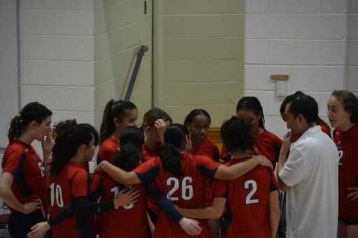 The Girls Varsity Volleyball team huddling during a game. The team had games scheduled on Rosh Hashanah and Yom Kippur this season. (Courtesy of Patrick Kaufmann)
